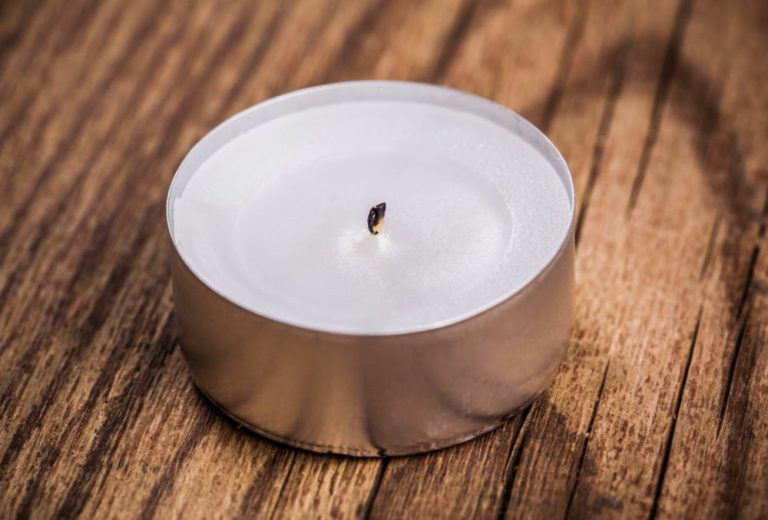 Candle wax on wood floor before safe removal using gentle heat or scraping methods