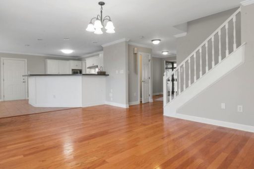 Newly stained hardwood floor in an open room showing a warmer tone and refreshed overall appearance
