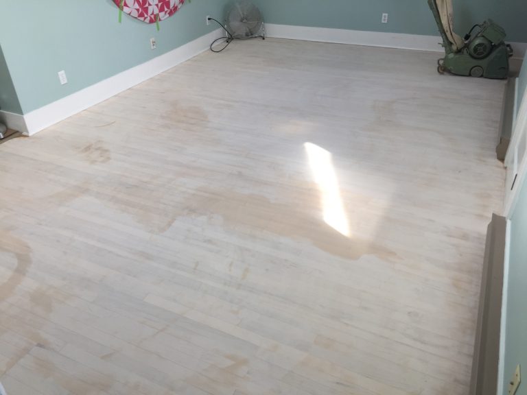 Hardwood floor prep before restoration showing sanded areas and uneven surface condition before refinishing