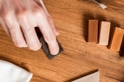 Repairing scratch on hardwood floor using touch up pad and color filler