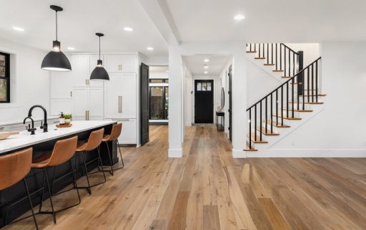 Refinished hand scraped hardwood floor in an open kitchen and hallway showing renewed texture and natural character