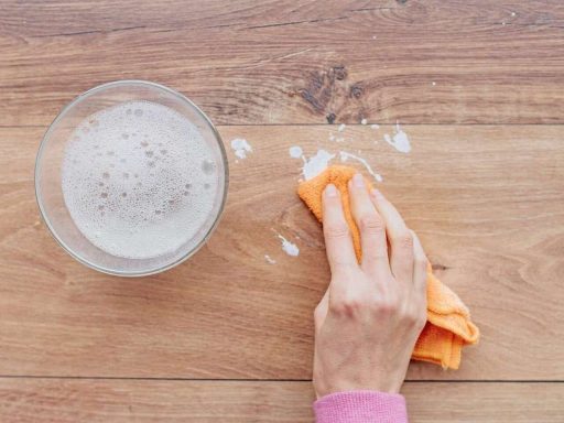 Removing paint from hardwood floors with a cloth and soapy water during the cleanup process