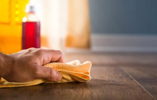 Removing hair dye from wood floor with a soft cloth before the stain sets into the surface