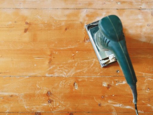 Sanding hardwood floor before finish to remove surface scratches and sanding marks