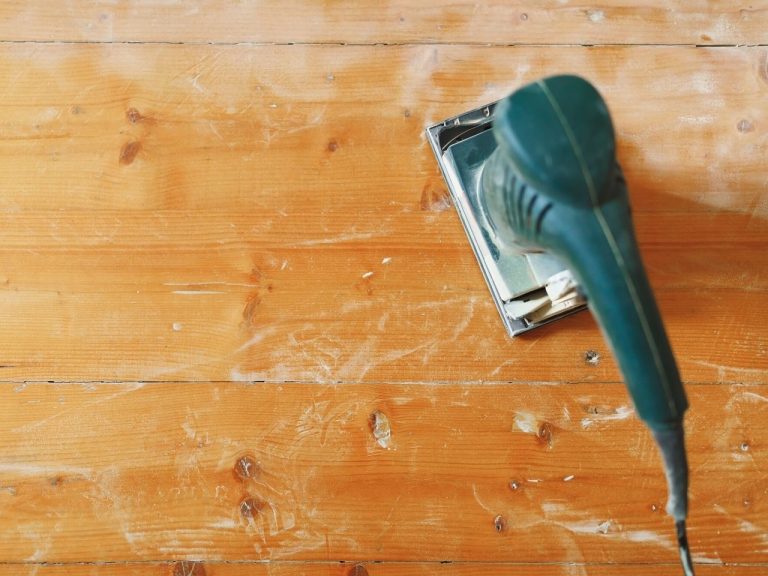 Sanding hardwood floor before finish to remove surface scratches and sanding marks