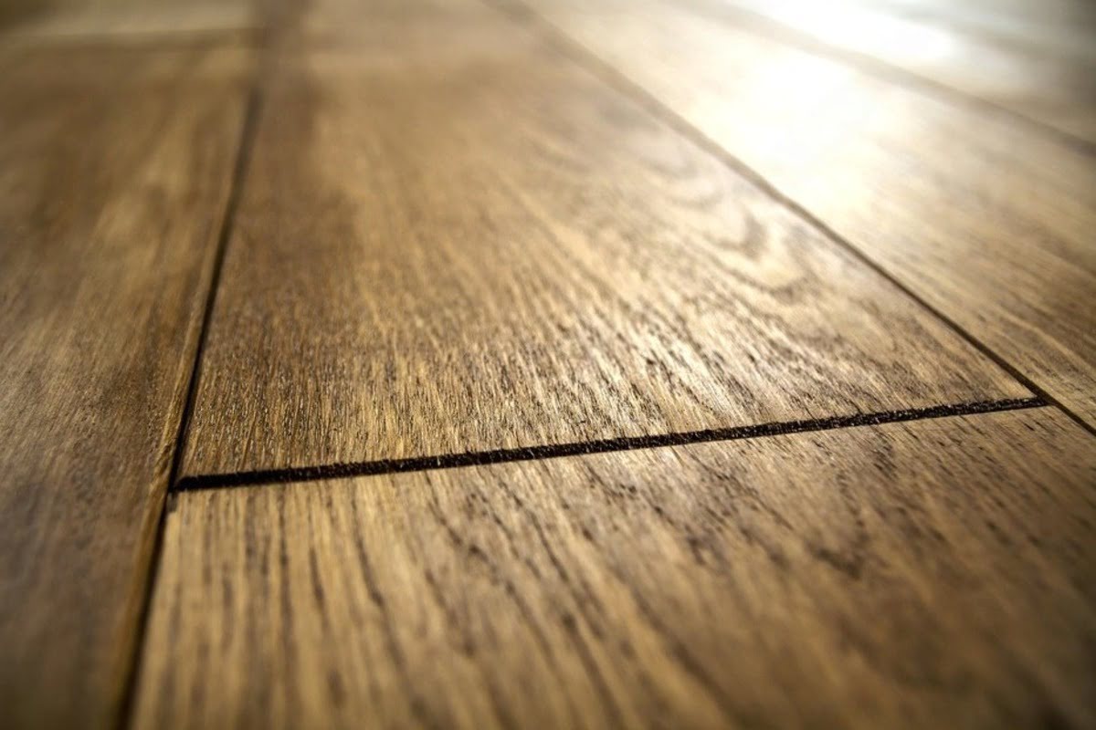 Hardwood floor near bed and furniture in a lived-in room with everyday foot traffic and floor-level obstacles