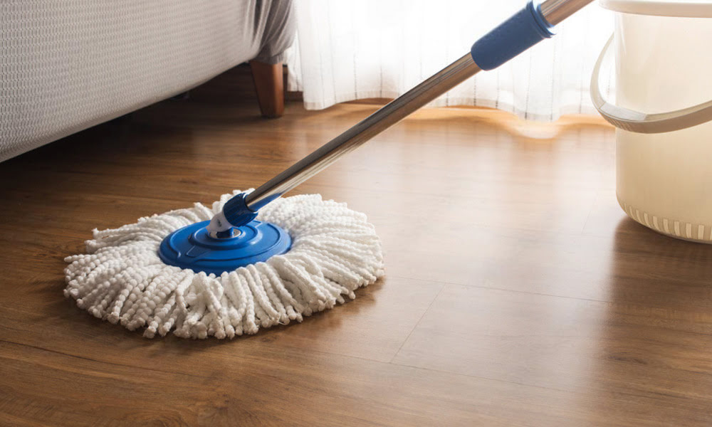 Mopping wood floor with a microfiber mop using a light surface-cleaning method for routine maintenance